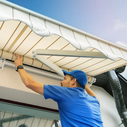 Reparatur Markise - Ein Handwerker montiert oder repariert eine Markise über der Terasse